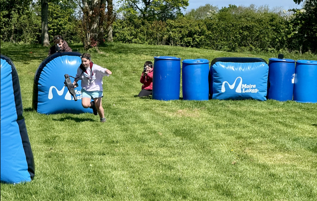 Young people playing outdoor laser tag among blue Moira Lakes barriers